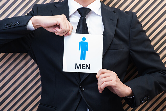 男性マークを両手で持つ男性のイメージ